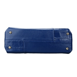 Bottom view of blue leather handbag showing lychee texture and gold protective studs