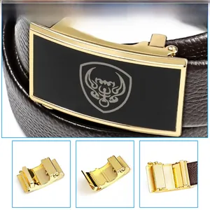 Detail of automatic alloy buckle with gold finish and brown lychee grain leather belt