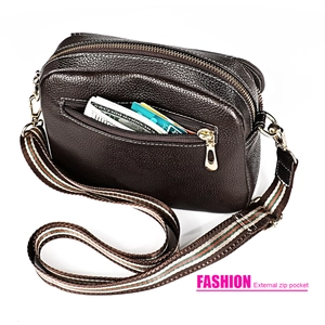 Detail of dark brown pebbled leather crossbody bag with external zip pocket and striped strap