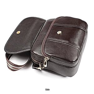 Detail view of brown pebbled leather crossbody bag with stitching and striped strap
