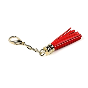 Detail view of a bright red leather tassel keychain with polished gold-tone lobster clasp