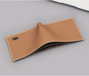 Close-up of brown leather bifold wallet with white stitching and metal logo detail