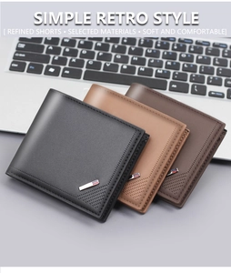 Close-up of three classic bifold wallets in black and brown on a laptop keyboard
