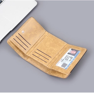 Detail of tan trifold wallet showing six card slots and a clear ID window on desk