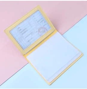 Detail of yellow faux leather organizer showing internal card slots and transparent windows