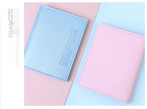 Detail of light blue and pink document holders showing embossed Chinese text and fine stitching