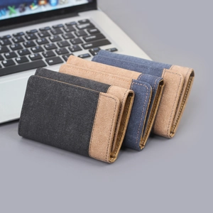 Three-fold canvas wallets in black, brown, and blue with premium leather stitching