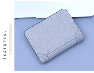 Close-up of light grey vertical canvas wallet with white stitching and textured fabric detail