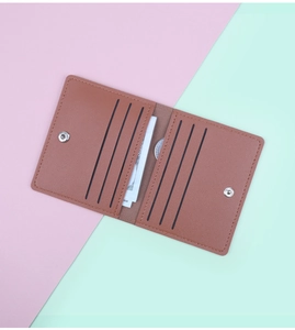 Détail de l'intérieur du porte-cartes en cuir marron avec six fentes et bouton pression
