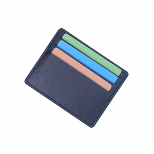 Slim navy blue leather card holder with three slots and contrast stitching on white background