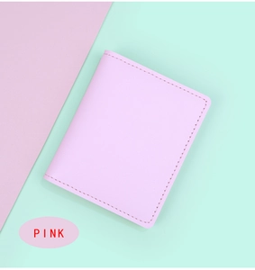 Détail de la texture en cuir grainé rose et des coutures du porte-cartes mince femme
