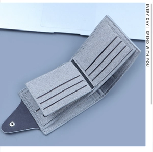 Detail view of the multi-slot interior and metal snap button on grey canvas wallet