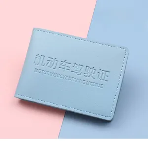 Close-up of light blue leather driver's license holder with detailed lychee grain texture