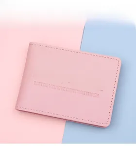 Detailed view of pink leather driver's license holder with fine lychee texture and stitching