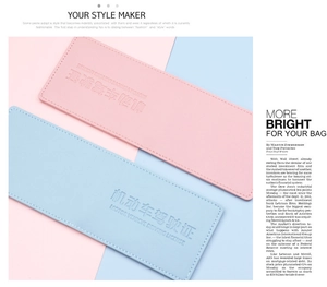 Close-up of pink and light blue PU leather driving license covers with embossed text