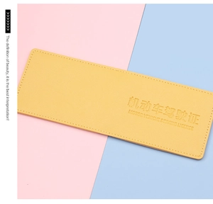 Close-up of bright yellow leather driving license holder with white stitching detail