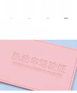 Macro shot of pink leather driver's license holder with detailed stitching and embossed text