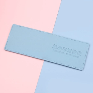 Light blue leather driving license holder with fine texture on a pastel background