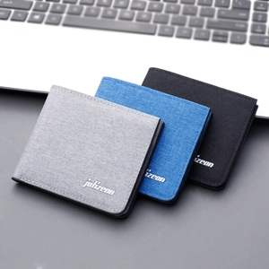Slim canvas bifold wallets for men in gray, blue and black on a desk background