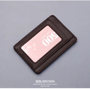 Detail view of a slim brown leather card holder featuring a clear ID window and fine stitching