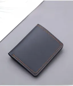 Macro view of vertical men's wallet featuring litchi grain texture and orange stitching