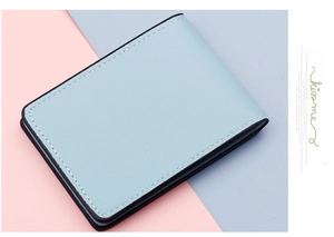 Détail du porte-cartes en similicuir bleu clair avec bords noirs et coutures blanches