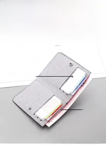 Detailed interior view of a slim grey canvas wallet with six card slots and cash pocket