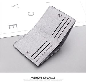 Detailed view of grey canvas wallet with six vertical card slots and silver snap button