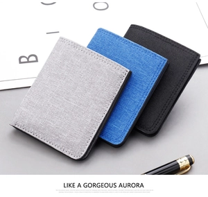 Detailed view of canvas bifold wallets in grey, blue, and black with woven texture
