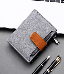 Close-up of a grey canvas wallet with a brown leather buckle and metal zipper