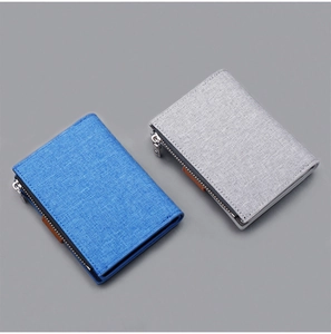 Detail view of canvas short wallets in blue and grey with metal zippers and textures