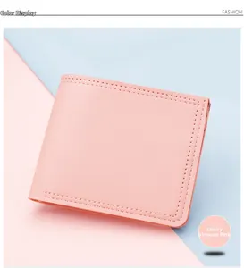 Detail der schmalen rosa Damen-Bifold-Brieftasche mit präzisen Nähten und PU-Leder-Textur