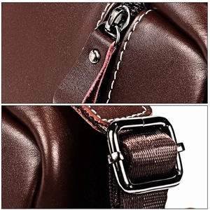 Detail of dark brown leather messenger bag featuring silver buckles and white contrast stitching