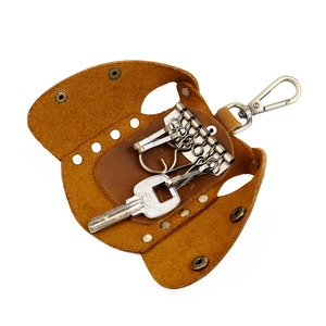 Detail of handmade brown leather key wallet with six bronze hooks and snap button closure