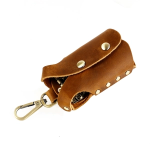 Macro detail of brown genuine leather key pouch featuring a vintage copper lobster clasp hook