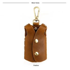 Macro shot of brown leather vest-shaped key pouch with metal snap buttons and carabiner