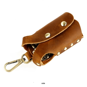 Detail view of brown genuine leather key case with vintage bronze hook and rivets