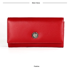 Detailed macro view of long red leather wallet featuring a vintage gold rose metal emblem