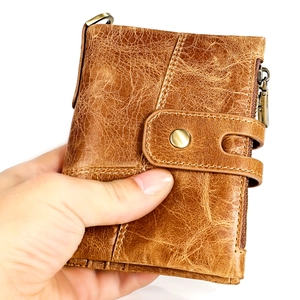 Détail d'un portefeuille en cuir marron vintage avec texture huilée et bouton à pression