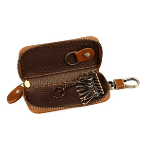 Close-up of brown leather car key case with six metal hooks and smooth zipper detail