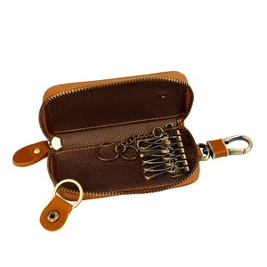 Detail view of brown genuine leather key case with metal hooks and U-shaped zipper