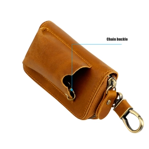 Detail view of vintage brown leather key pouch with bronze hook and chain buckle feature