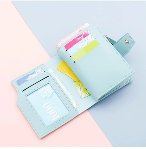 Detail view of light blue tri-fold wallet showing multiple card slots and ID window