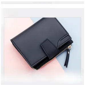 Detail of black pebbled leather short wallet with gold zipper and snap closure mechanism