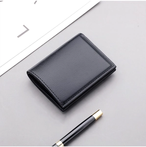 Detail of slim black leather wallet with lychee grain texture and minimalist bifold design