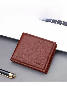 Detailopname van een bruine herenportemonnee van generfd leer op een bureau in kantoor