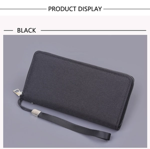 Detail of black canvas wristlet wallet showing zipper closure and textured fabric