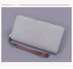 Macro shot of grey canvas texture and durable wrist strap on men's long zip wallet
