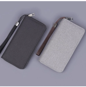 Detailed view of grey and black canvas wallets with metal zippers and wrist straps