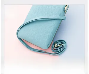 Dettaglio della borsa porta cellulare in pelle azzurra con trama litchi e metallo oro
